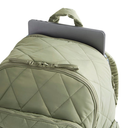 Green quilted backpack with a laptop inside on a white background