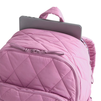 Pink quilted backpack with a tablet on a white background